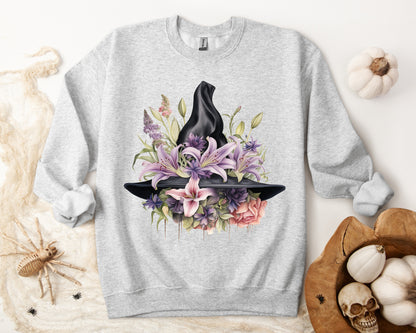 Mystical Floral Witch Hat Sweatshirt featuring a watercolor illustration of a black witch hat with flowers in purple, pink, and green. Available in multiple dark and light colors and sizes. Gildan 18000 sweatshirt in ash. ReadyShirtAim.com