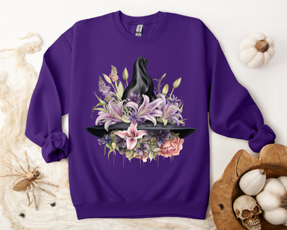 Mystical Floral Witch Hat Sweatshirt featuring a watercolor illustration of a black witch hat with flowers in purple, pink, and green. Available in multiple dark and light colors and sizes. Gildan 18000 sweatshirt in Purple. ReadyShirtAim.com