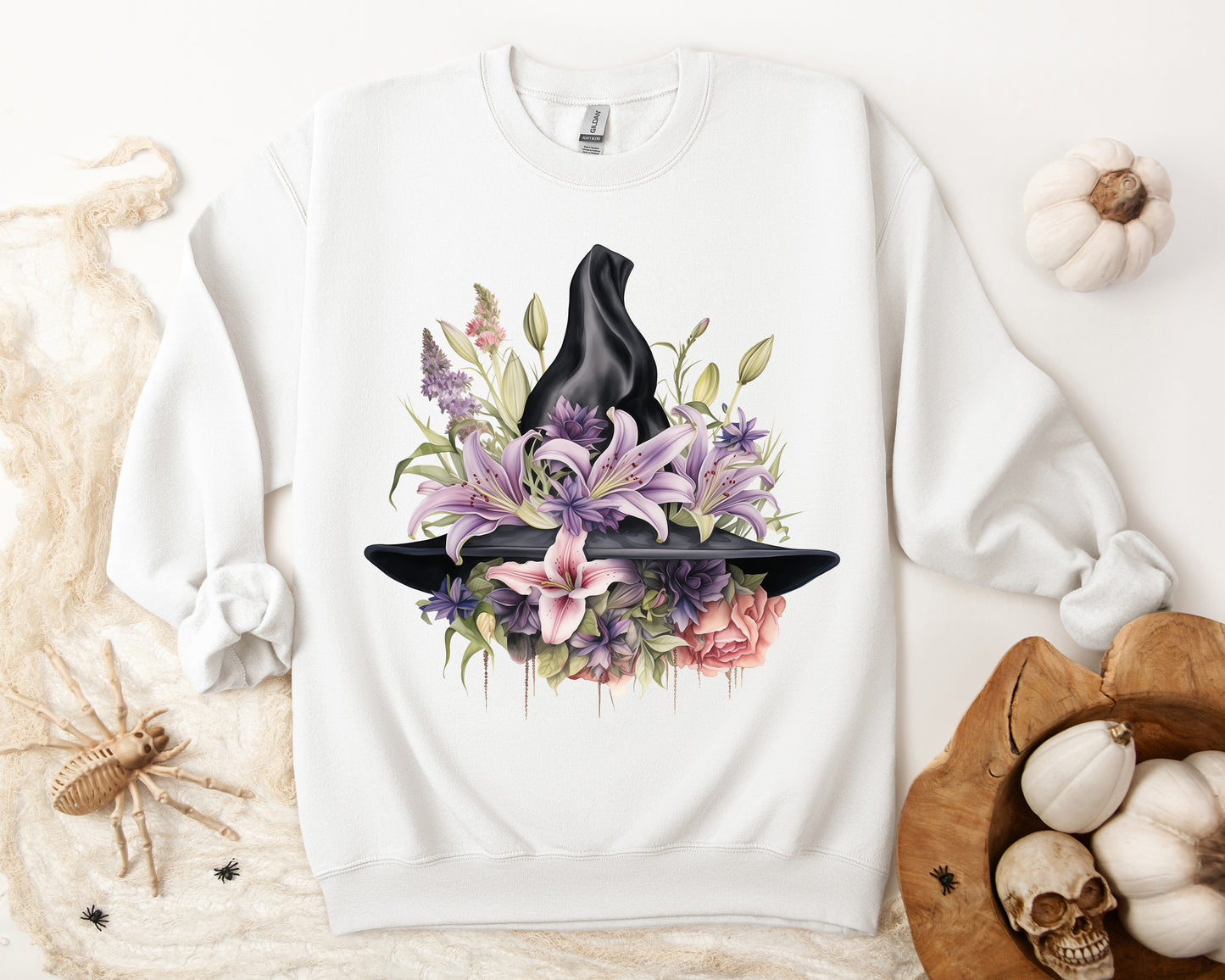 Mystical Floral Witch Hat Sweatshirt featuring a watercolor illustration of a black witch hat with flowers in purple, pink, and green. Available in multiple dark and light colors and sizes. Gildan 18000 sweatshirt in white. ReadyShirtAim.com