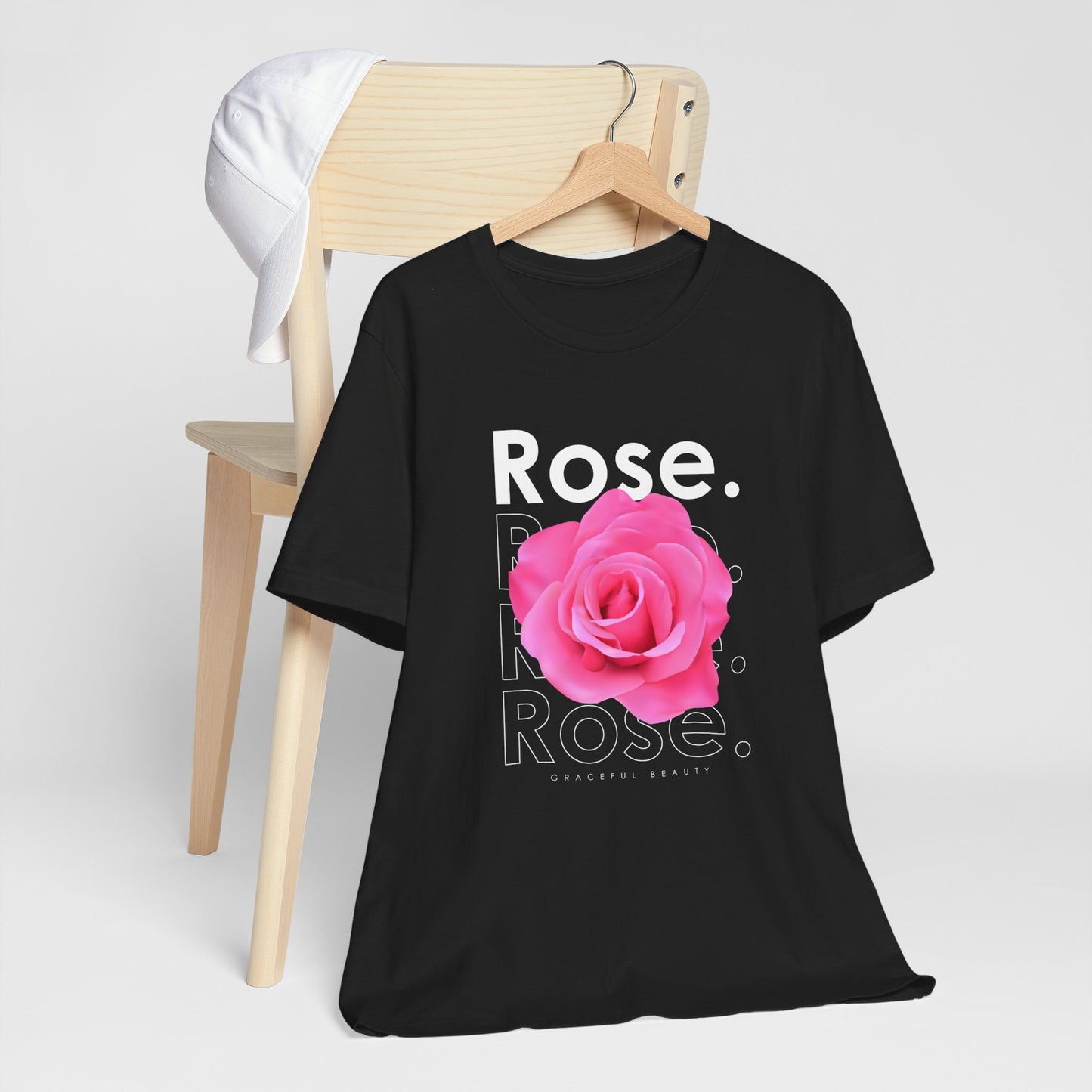 A t-shirt featuring a beautiful pink photo-realistic rose with the theme 'Graceful Beauty.' Perfect for those who adore floral art and nature. Comfortable and stylish for casual outings or celebrations. Bella+Canvas 3001 t-shirt in black. ReadyShirtAim.com