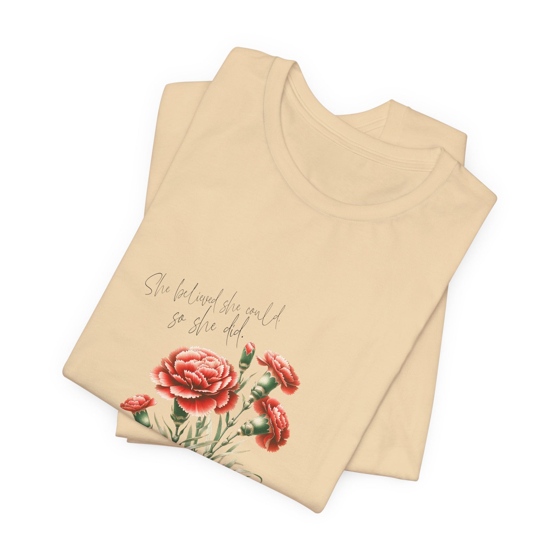 A t-shirt featuring a beautiful carnation for January with the quote “She believed she could, so she did.” Perfect for January birthdays and floral art lovers. Comfortable and stylish for casual outings or celebrations. Bella+Canvas 3001 t-shirt in soft cream. ReadyShirtAim.com