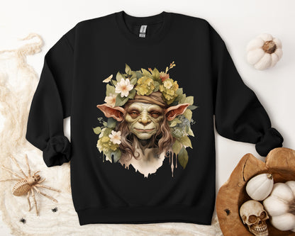 Creepy Cute Goblin Floral Boho Halloween Sweatshirt for women. Features a charming goblin surrounded by muted florals. Perfect for Halloween celebrations. Available in multiple dark and light colors and sizes. Gildan 18000 sweatshirt in Black. ReadyShirtAim.com