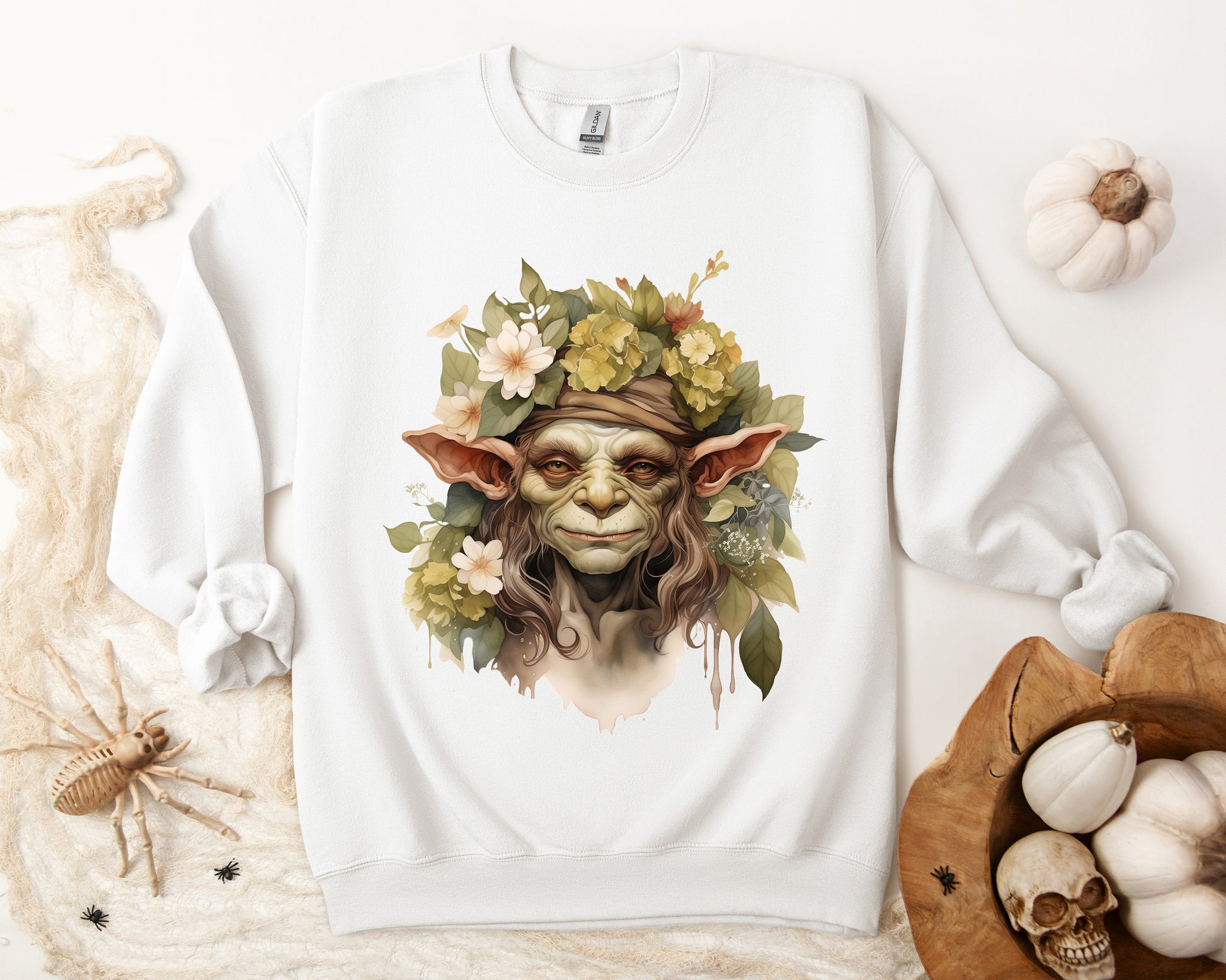 Creepy Cute Goblin Floral Boho Halloween Sweatshirt for women. Features a charming goblin surrounded by muted florals. Perfect for Halloween celebrations. Available in multiple dark and light colors and sizes. Gildan 18000 sweatshirt in white. ReadyShirtAim.com