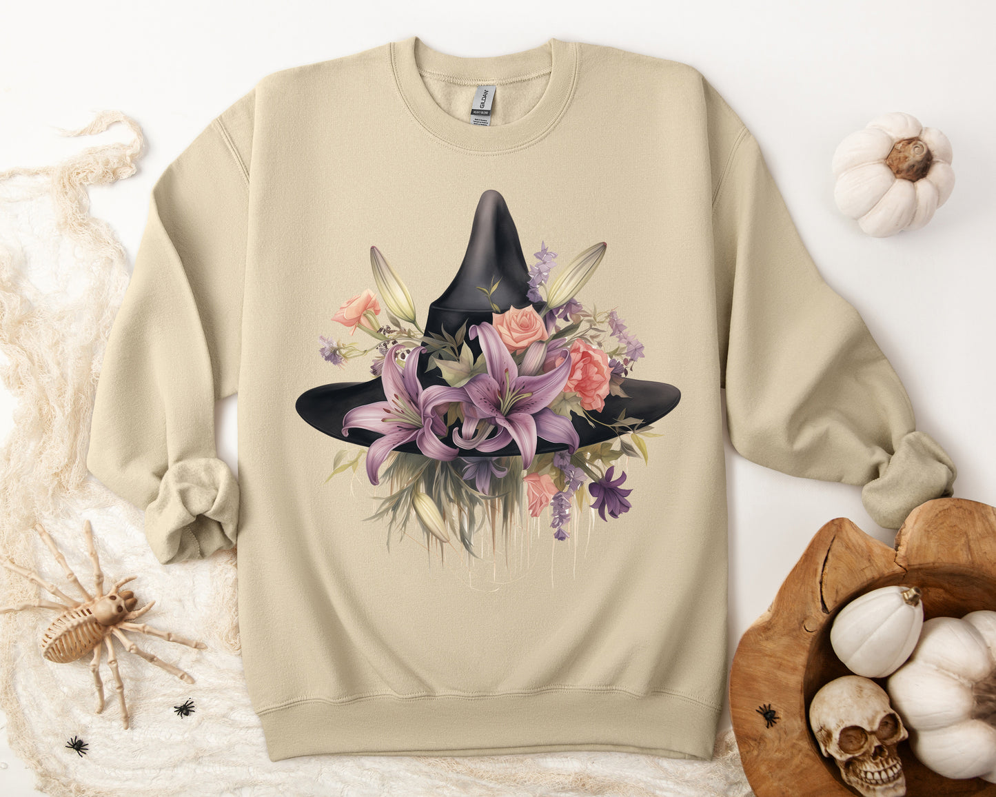 Elegant Witchy Blooms Sweatshirt with a watercolor illustration of a black witch hat and flowers in purple, pink, and green. Available in multiple dark and light colors and sizes. Gildan 18000 sweatshirt in Sand. ReadyShirtAim.com