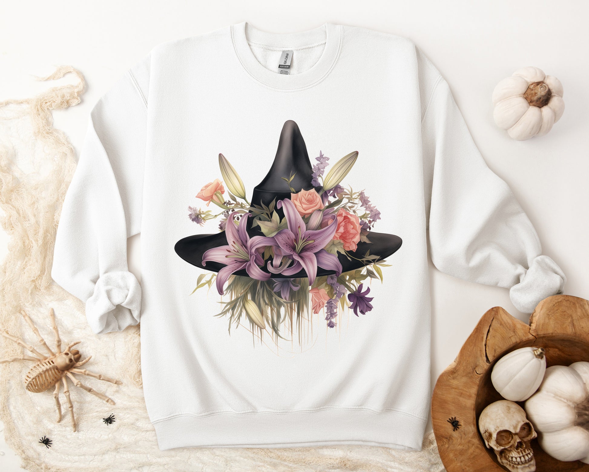 Elegant Witchy Blooms Sweatshirt with a watercolor illustration of a black witch hat and flowers in purple, pink, and green. Available in multiple dark and light colors and sizes. Gildan 18000 sweatshirt in white. ReadyShirtAim.com