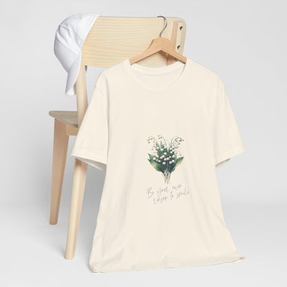 A t-shirt featuring a beautiful Lily of the Valley for May with the quote “Be your own reason to smile.” Perfect for May birthdays and floral art lovers. Comfortable and stylish for casual outings or celebrations. Bella+Canvas 3001 t-shirt in natural. ReadyShirtAim.com