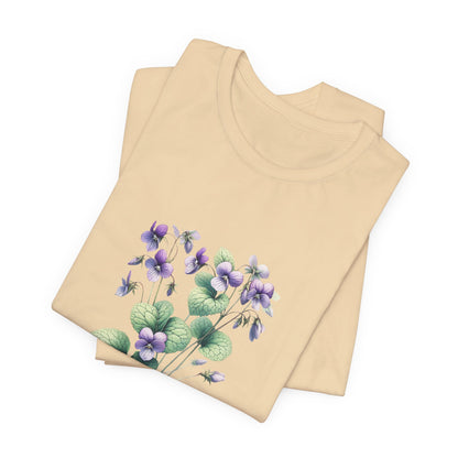 A t-shirt featuring a beautiful violet for February. Perfect for February birthdays and floral art lovers. Comfortable and stylish for casual outings or celebrations. Bella+Canvas 3001 t-shirt in soft cream. ReadyShirtAim.com