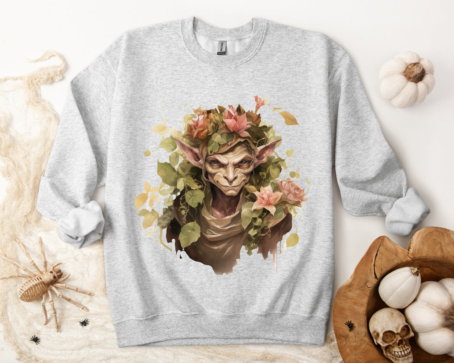 Boho Goblin Magic Halloween Sweatshirt for women. Features a charming goblin surrounded by muted florals. Perfect for Halloween celebrations. Available in multiple dark and light colors and sizes. Gildan 18000 sweatshirt in ash. ReadyShirtAim.com