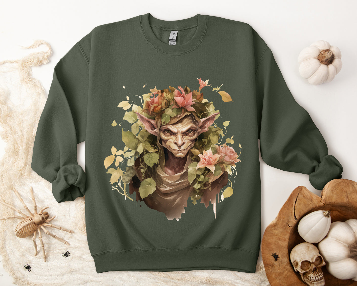 Boho Goblin Magic Halloween Sweatshirt for women. Features a charming goblin surrounded by muted florals. Perfect for Halloween celebrations. Available in multiple dark and light colors and sizes. Gildan 18000 sweatshirt in Military Green. ReadyShirtAim.com