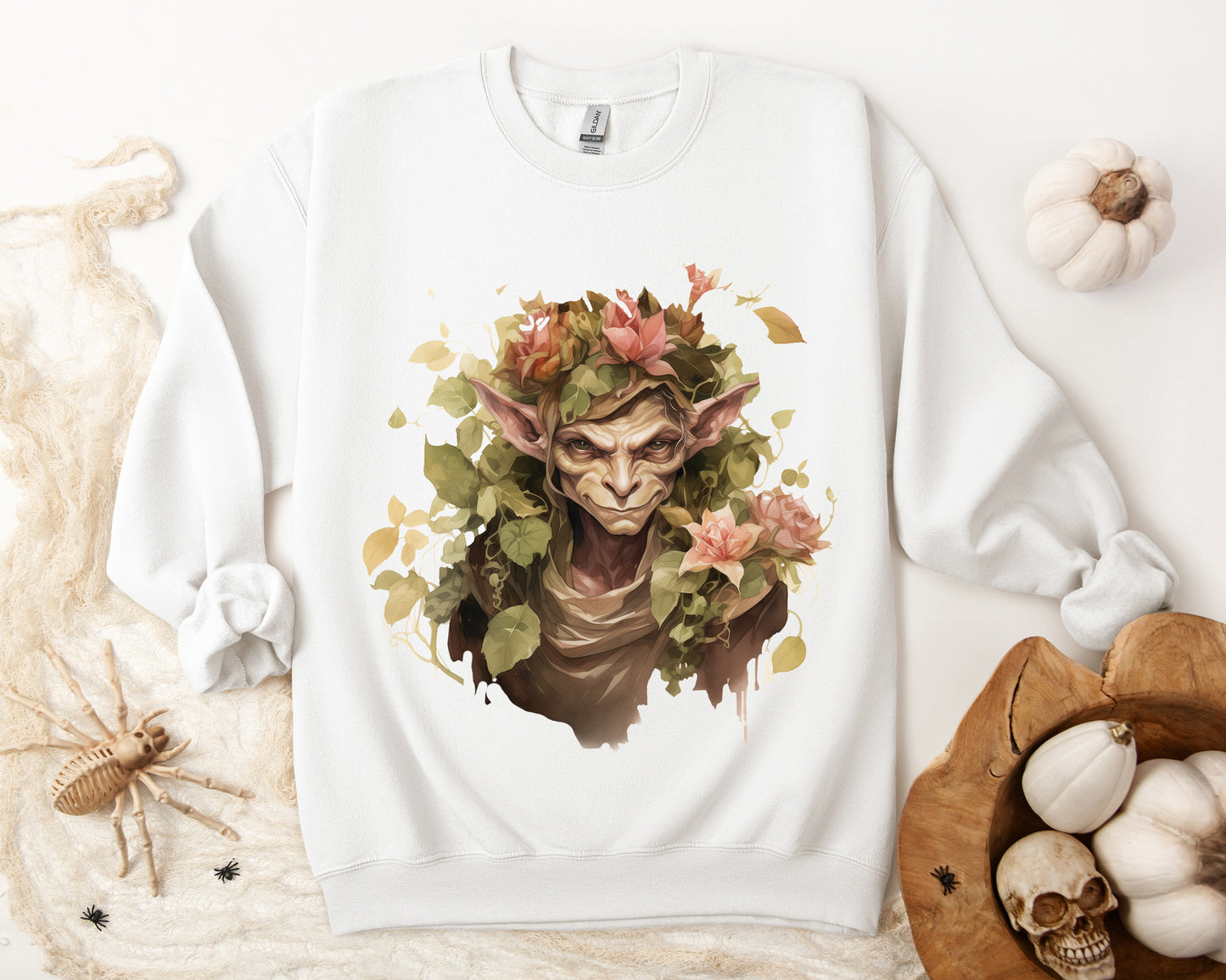 Boho Goblin Magic Halloween Sweatshirt for women. Features a charming goblin surrounded by muted florals. Perfect for Halloween celebrations. Available in multiple dark and light colors and sizes. Gildan 18000 sweatshirt in white. ReadyShirtAim.com