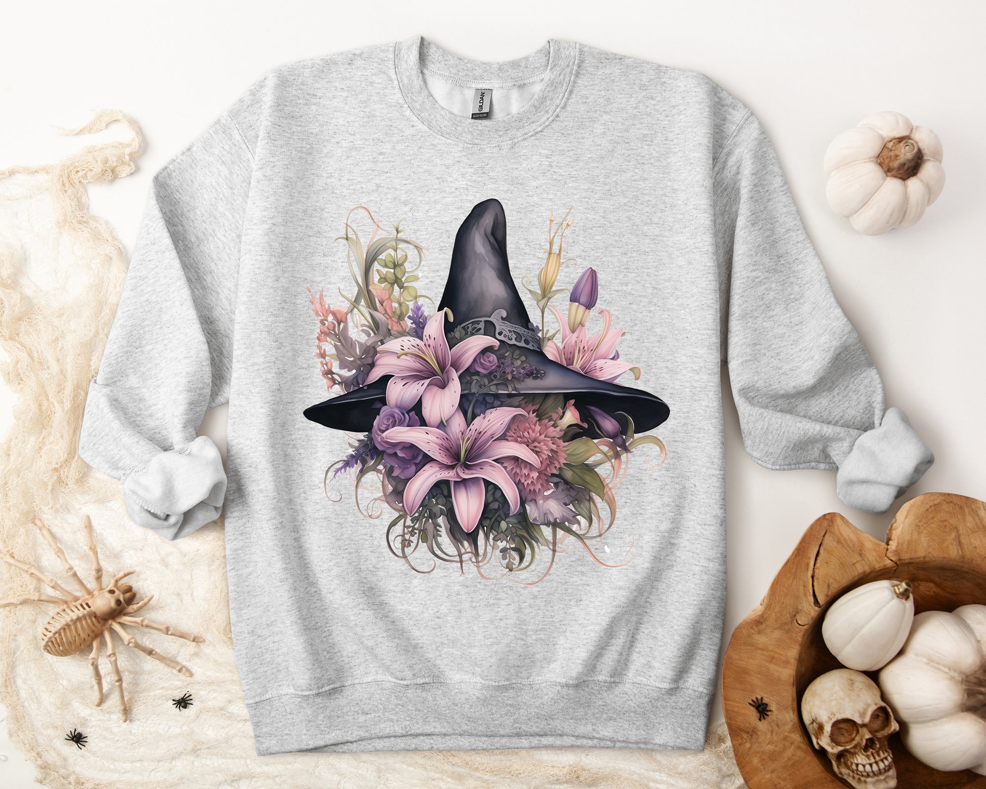 Charming Witch Hat & Flowers Sweatshirt with a watercolor illustration of a black witch hat and flowers in purple, pink, and green. Available in multiple dark and light colors and sizes. Gildan 18000 sweatshirt in ash. ReadyShirtAim.com