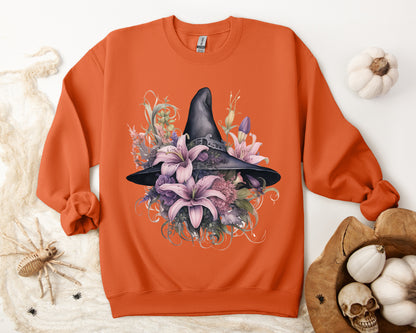 Charming Witch Hat & Flowers Sweatshirt with a watercolor illustration of a black witch hat and flowers in purple, pink, and green. Available in multiple dark and light colors and sizes. Gildan 18000 sweatshirt in Orange. ReadyShirtAim.com