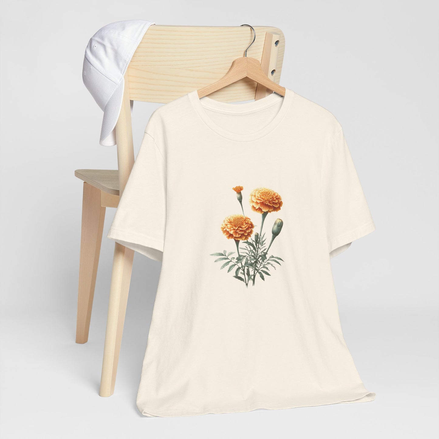 A t-shirt featuring a beautiful marigold for October. Perfect for October birthdays and floral art lovers. Comfortable and stylish for casual outings or celebrations. Bella+Canvas 3001 t-shirt in natural. ReadyShirtAim.com