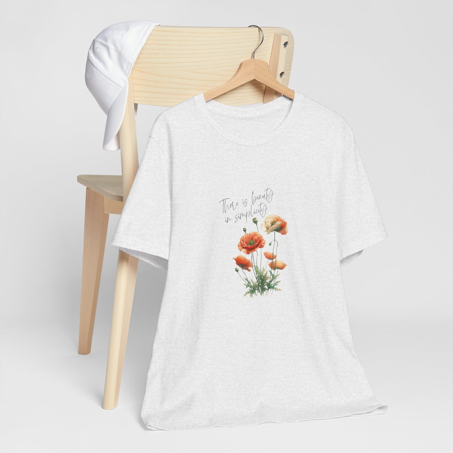 A t-shirt featuring a beautiful poppy for August with the quote “There is beauty in simplicity.” Perfect for August birthdays and floral art lovers. Comfortable and stylish for casual outings or celebrations. Bella+Canvas 3001 t-shirt in ash. ReadyShirtAim.com