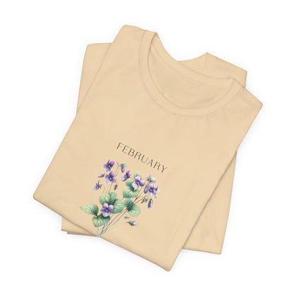 A t-shirt featuring a beautiful violet for February with traits Virtue, Modesty, Humility. Perfect for February birthdays and floral art lovers. Comfortable and stylish for casual outings or celebrations. Bella+Canvas 3001 t-shirt in soft cream. ReadyShirtAim.com