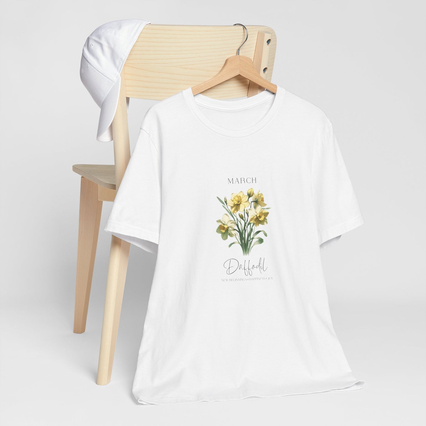 A t-shirt featuring a beautiful daffodil for March with traits New Beginnings, Happiness, Joy. Perfect for March birthdays and floral art lovers. Comfortable and stylish for casual outings or celebrations. Bella+Canvas 3001 t-shirt in white. ReadyShirtAim.com