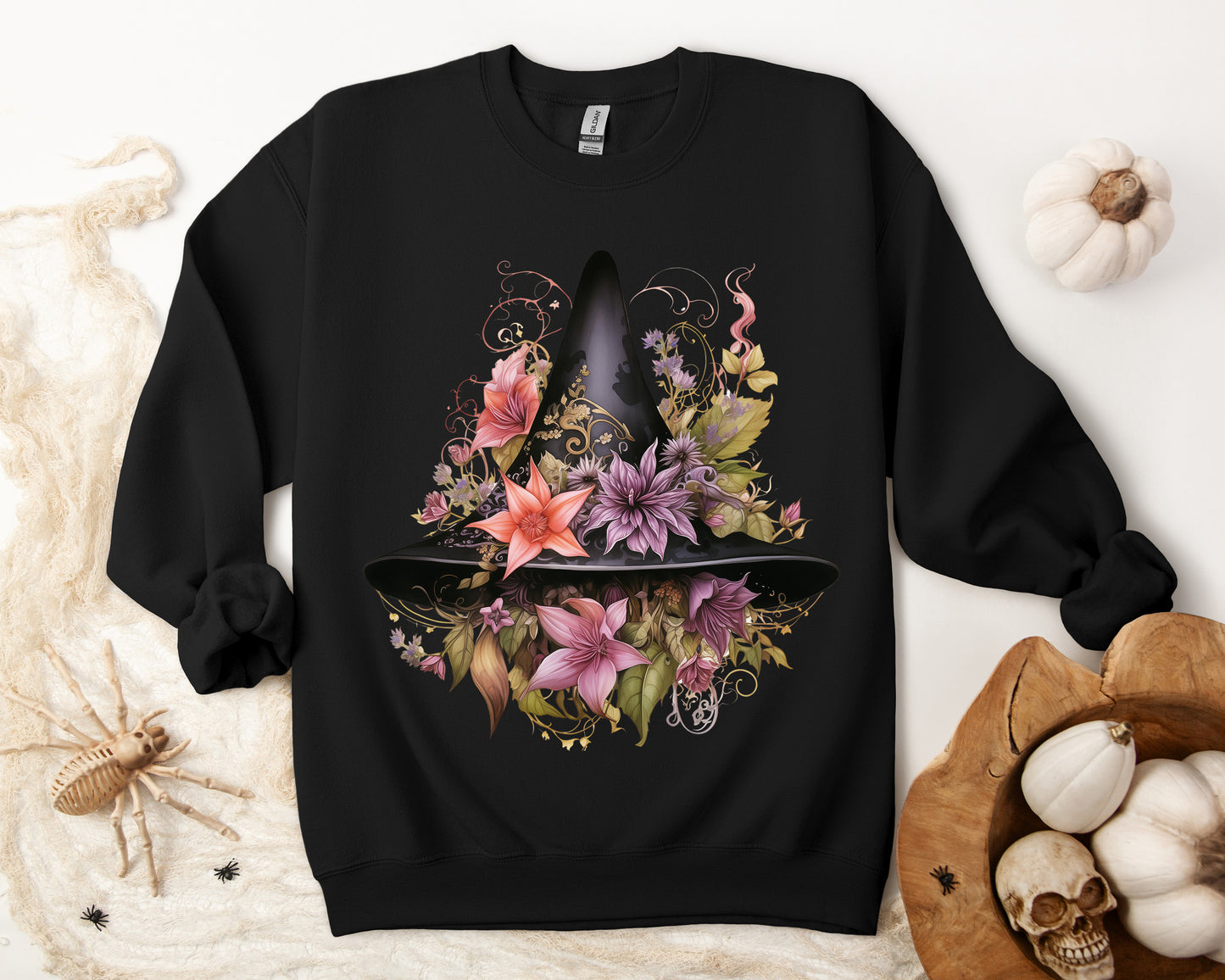 Whimsical Witch Hat Sweatshirt with a watercolor illustration of a black witch hat surrounded by flowers in purple, pink, and green. Available in multiple dark and light colors and sizes. Gildan 18000 sweatshirt in Black. ReadyShirtAim.com