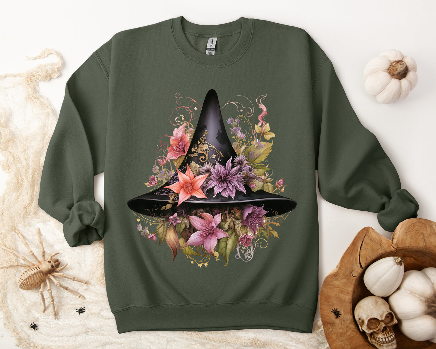 Whimsical Witch Hat Sweatshirt with a watercolor illustration of a black witch hat surrounded by flowers in purple, pink, and green.. Available in multiple dark and light colors and sizes. Gildan 18000 sweatshirt in Military Green. ReadyShirtAim.com