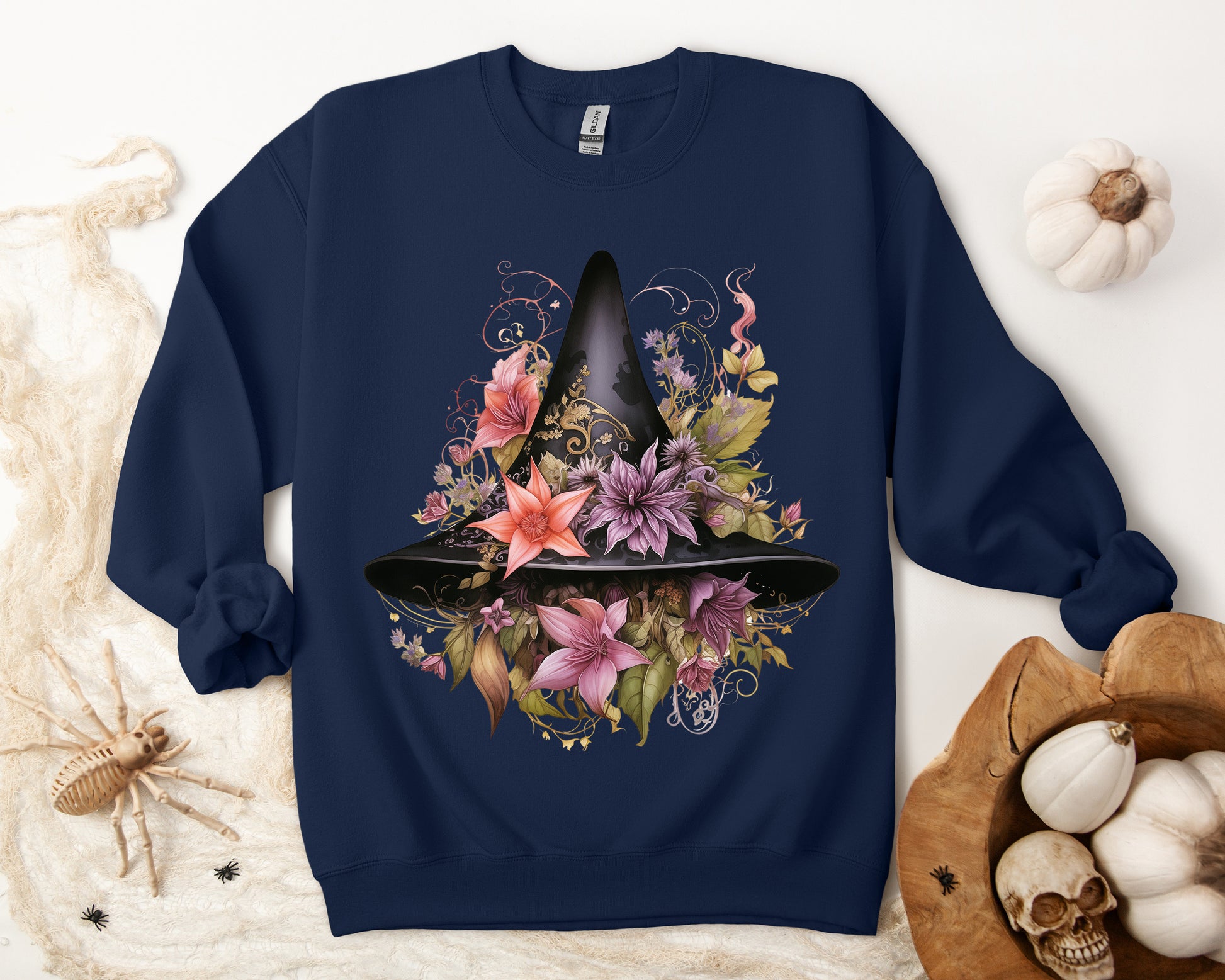 Whimsical Witch Hat Sweatshirt with a watercolor illustration of a black witch hat surrounded by flowers in purple, pink, and green. Available in multiple dark and light colors and sizes. Gildan 18000 sweatshirt in Navy. ReadyShirtAim.com