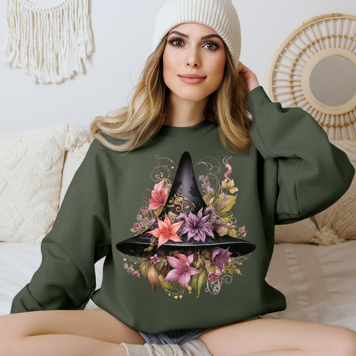 Whimsical Witch Hat Sweatshirt with a watercolor illustration of a black witch hat surrounded by flowers in purple, pink, and green.. Available in multiple dark and light colors and sizes. Gildan 18000 sweatshirt in Military Green. ReadyShirtAim.com