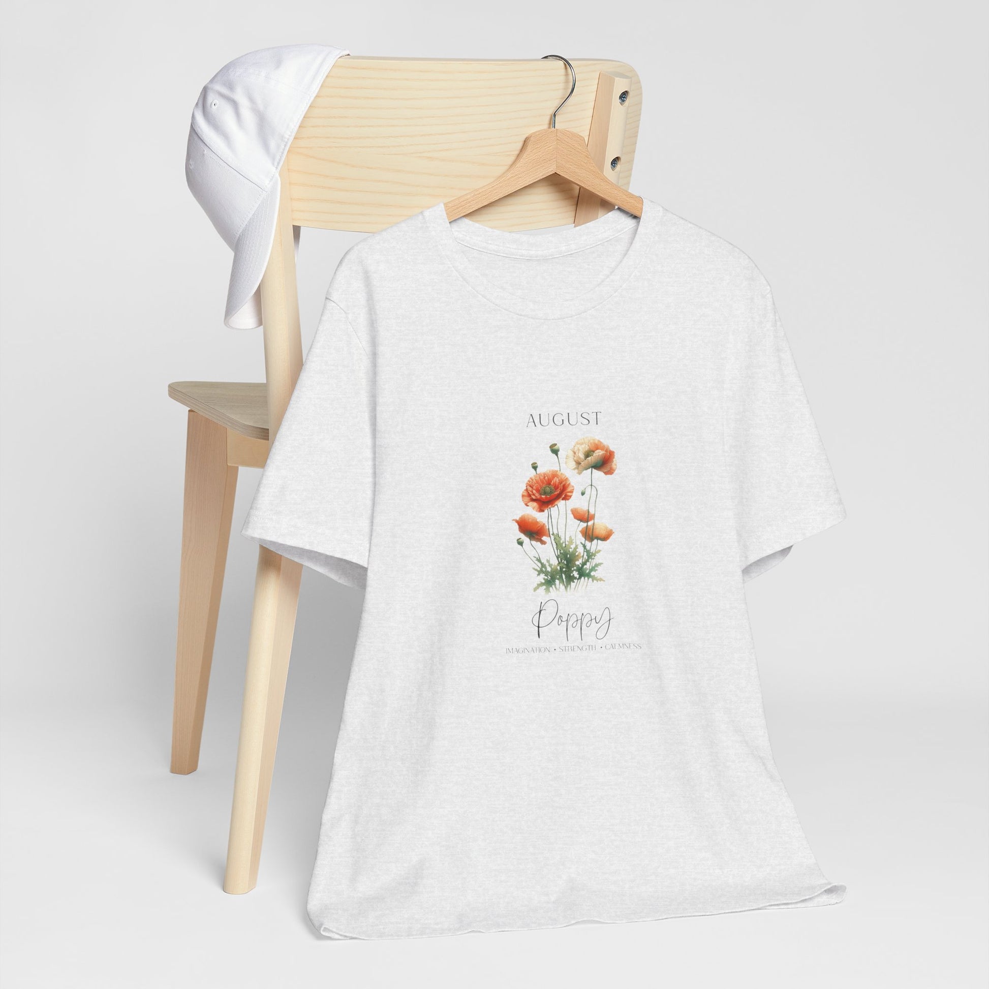 A t-shirt featuring a beautiful poppy for August with traits Imagination, Strength, Calmness. Perfect for August birthdays and floral art lovers. Comfortable and stylish for casual outings or celebrations. Bella+Canvas 3001 t-shirt in ash. ReadyShirtAim.com