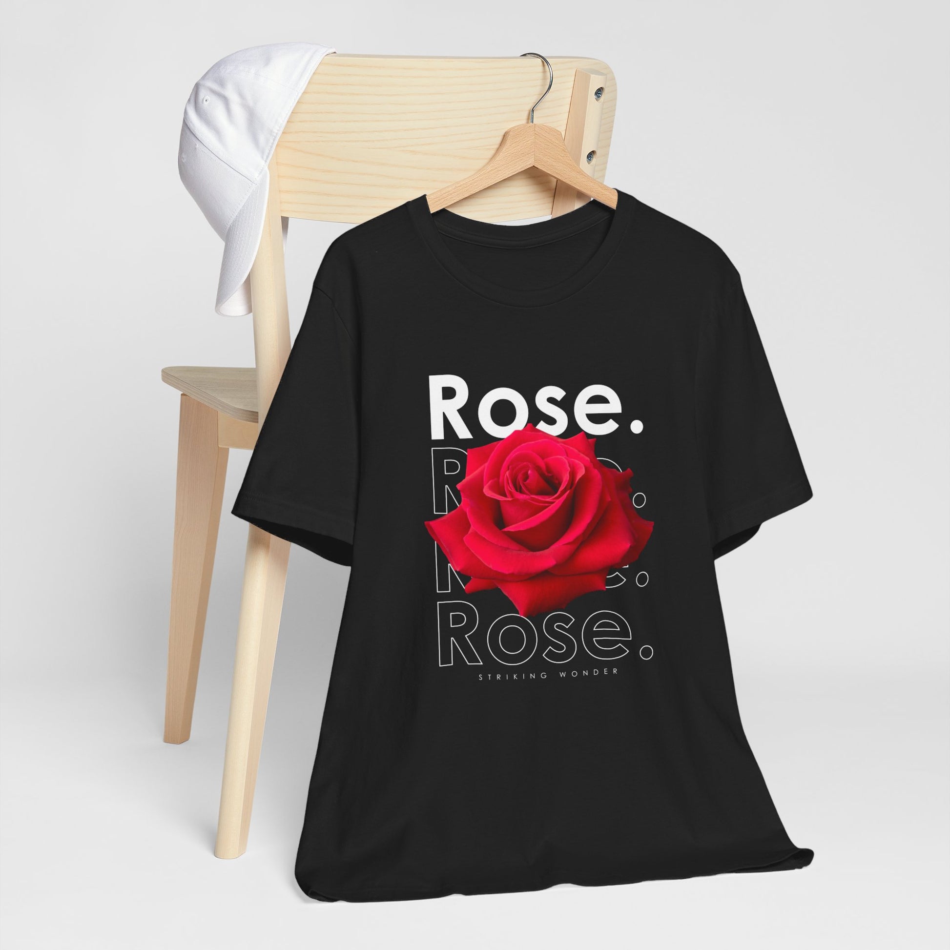 A t-shirt featuring a stunning deep red photo-realistic rose with the theme 'Striking Wonder.' Perfect for those who adore bold floral art and nature. Comfortable and stylish for casual outings or celebrations. Bella+Canvas 3001 t-shirt in black. ReadyShirtAim.com