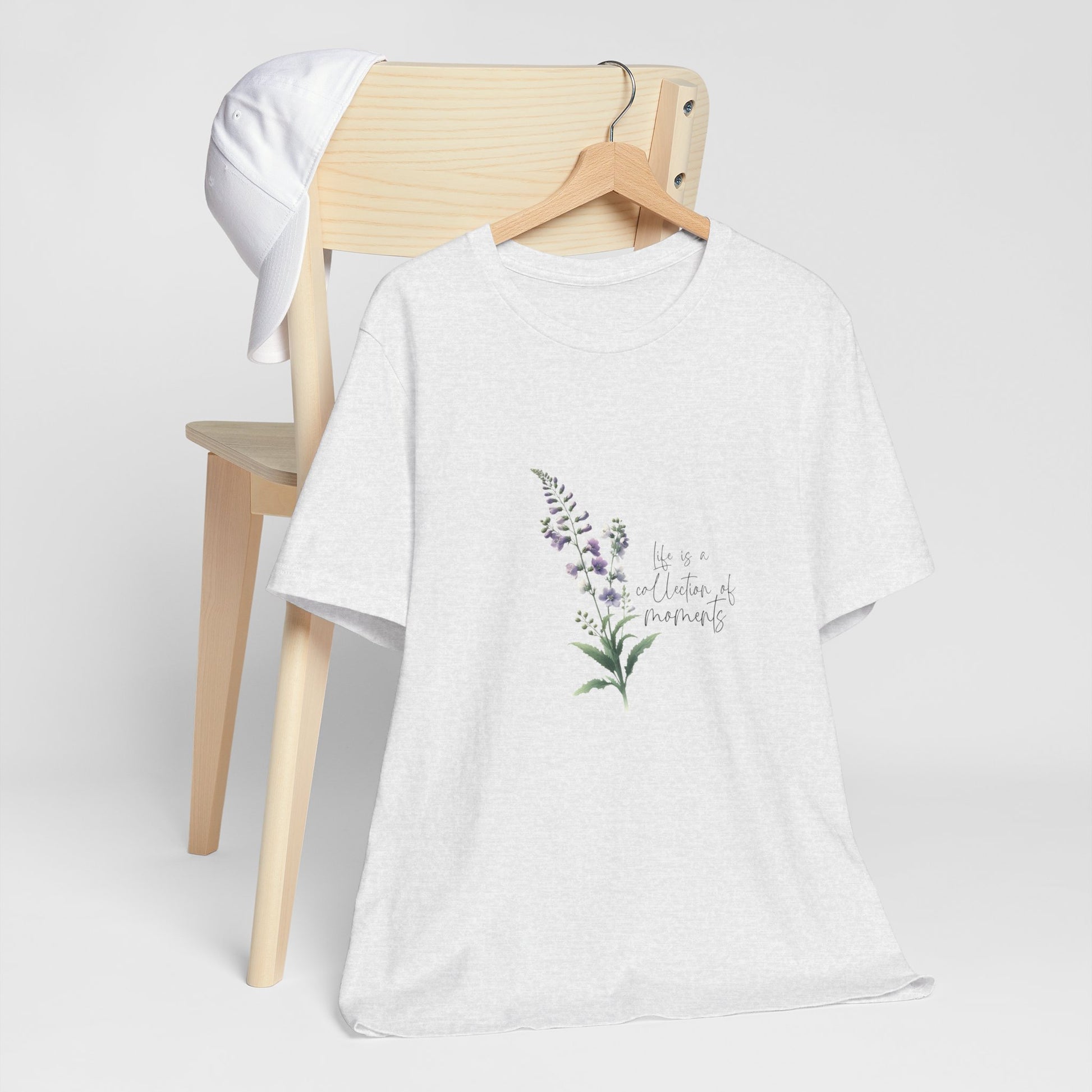 A t-shirt featuring a beautiful larkspur for July with the quote “Life is a collection of moments.” Perfect for July birthdays and floral art lovers. Comfortable and stylish for casual outings or celebrations. Bella+Canvas 3001 t-shirt in ash. ReadyShirtAim.com