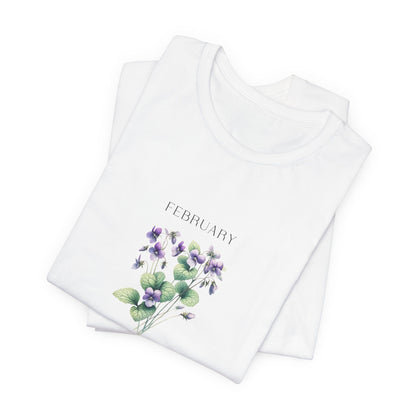 A t-shirt featuring a beautiful violet for February with traits Virtue, Modesty, Humility. Perfect for February birthdays and floral art lovers. Comfortable and stylish for casual outings or celebrations. Bella+Canvas 3001 t-shirt in white. ReadyShirtAim.com