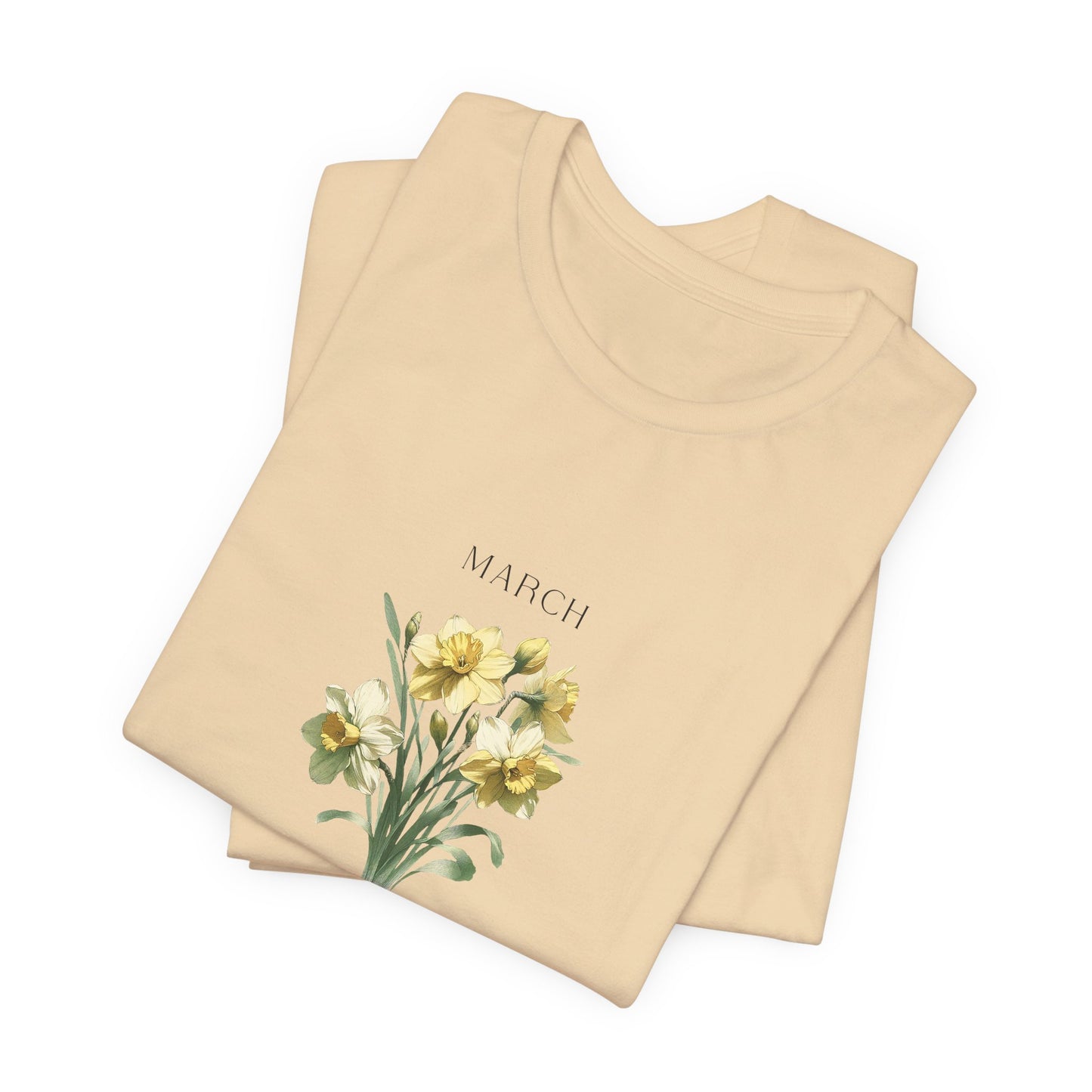 A t-shirt featuring a beautiful daffodil for March with traits New Beginnings, Happiness, Joy. Perfect for March birthdays and floral art lovers. Comfortable and stylish for casual outings or celebrations. Bella+Canvas 3001 t-shirt in soft cream. ReadyShirtAim.com