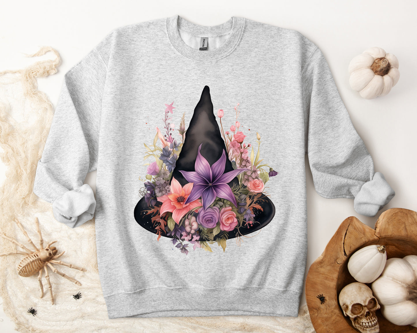 Feminine Witchy Vibes Boho Halloween Sweatshirt for her, featuring a watercolor illustration of a black witch hat and flowers in purple, pink, and green. Available in multiple dark and light colors and sizes. Gildan 18000 sweatshirt in ash. ReadyShirtAim.com