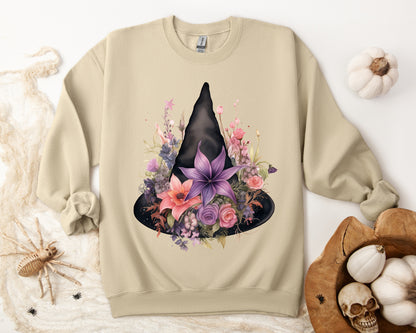 Feminine Witchy Vibes Boho Halloween Sweatshirt for her, featuring a watercolor illustration of a black witch hat and flowers in purple, pink, and green. Available in multiple dark and light colors and sizes. Gildan 18000 sweatshirt in Sand. ReadyShirtAim.com