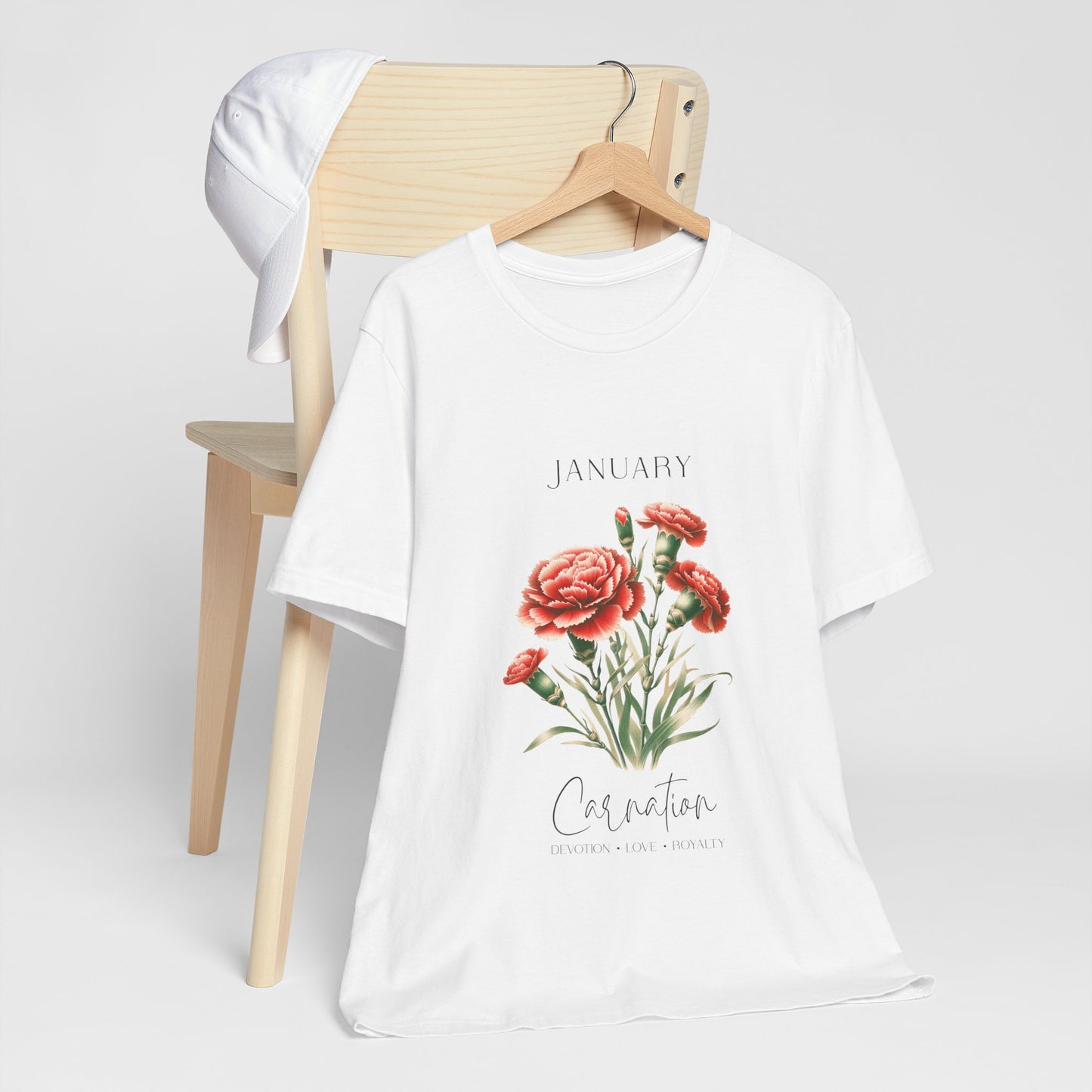 A t-shirt featuring a beautiful carnation for January with traits Devotion, Love, Loyalty. Perfect for January birthdays and floral art lovers. Comfortable and stylish for casual outings or celebrations. Bella+Canvas 3001 t-shirt in white. ReadyShirtAim.com