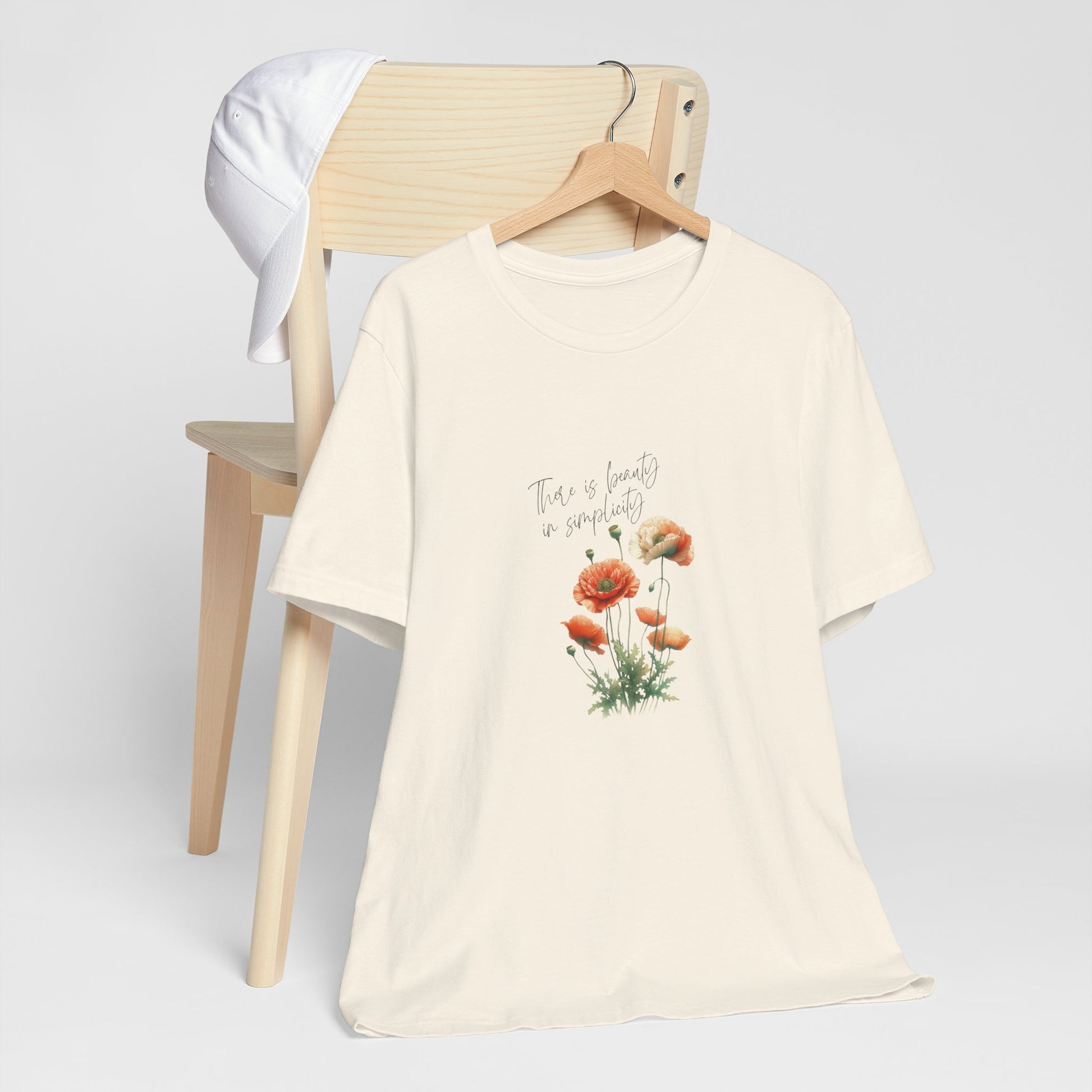 A t-shirt featuring a beautiful poppy for August with the quote “There is beauty in simplicity.” Perfect for August birthdays and floral art lovers. Comfortable and stylish for casual outings or celebrations. Bella+Canvas 3001 t-shirt in natural. ReadyShirtAim.com