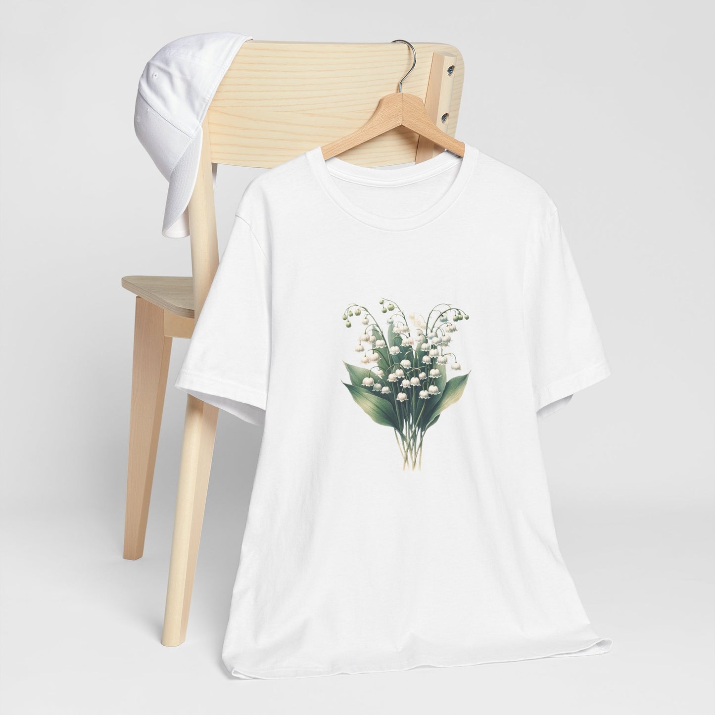 A t-shirt featuring a beautiful Lily of the Valley for May. Perfect for May birthdays and floral art lovers. Comfortable and stylish for casual outings or celebrations. Bella+Canvas 3001 t-shirt in white. ReadyShirtAim.com