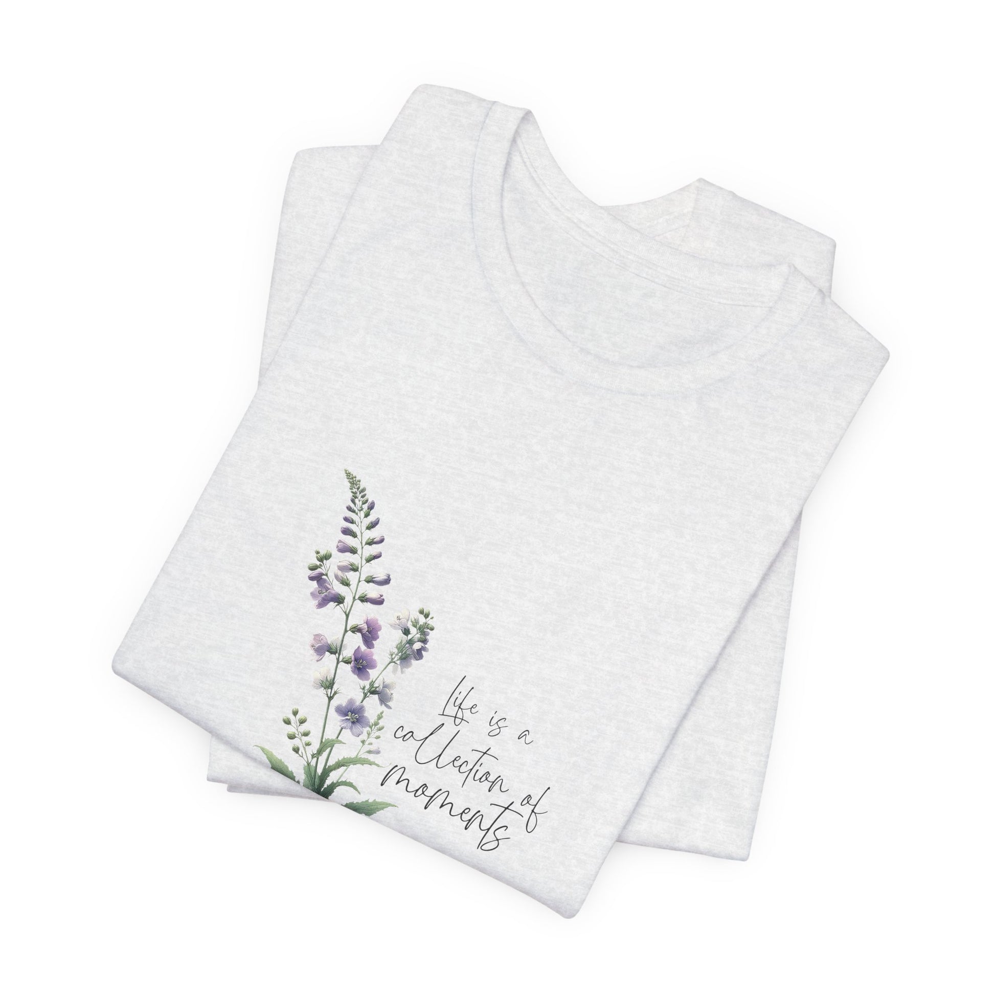 A t-shirt featuring a beautiful larkspur for July with the quote “Life is a collection of moments.” Perfect for July birthdays and floral art lovers. Comfortable and stylish for casual outings or celebrations. Bella+Canvas 3001 t-shirt in ash. ReadyShirtAim.com