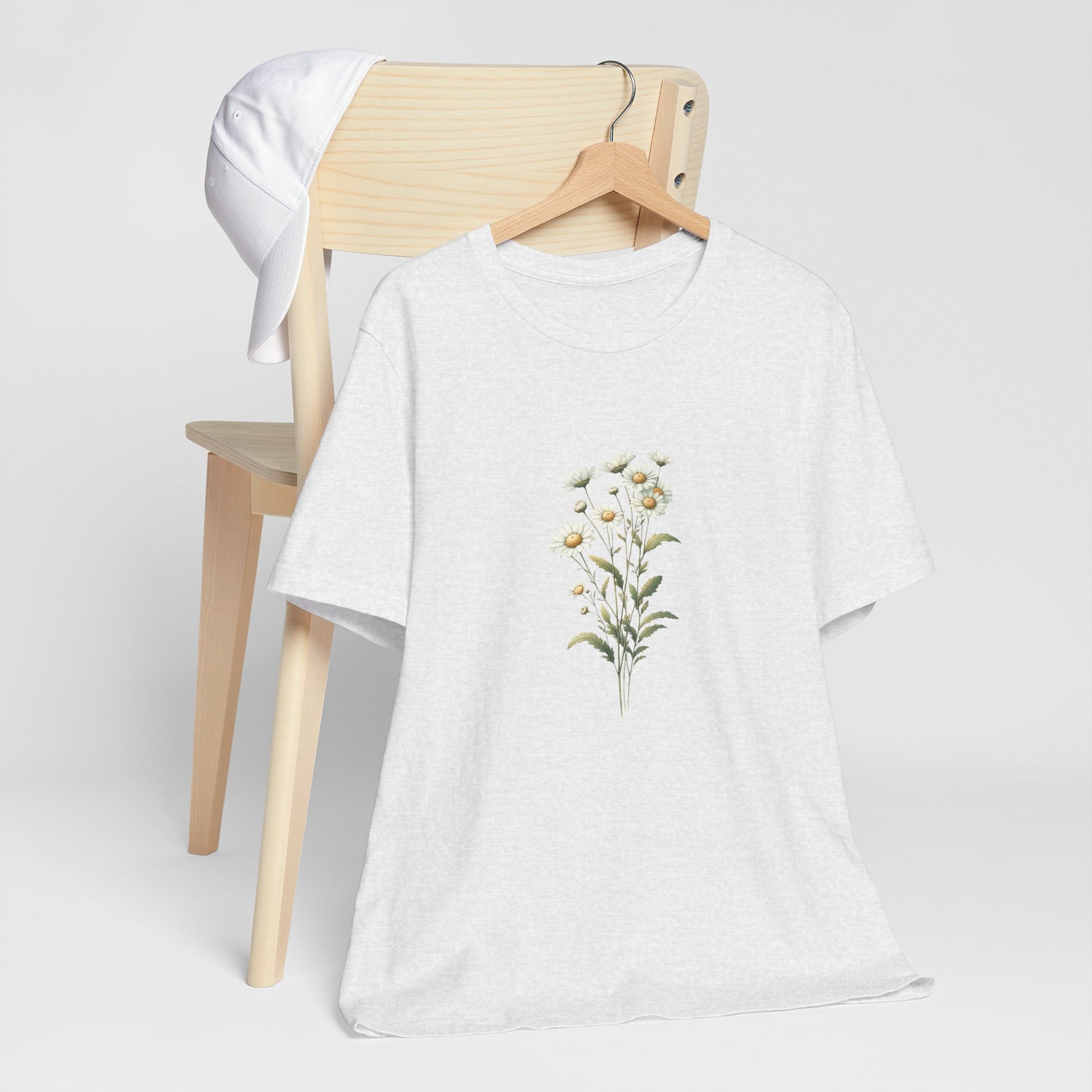 A t-shirt featuring a beautiful daisy for April. Perfect for April birthdays and floral art lovers. Comfortable and stylish for casual outings or celebrations. Bella+Canvas 3001 t-shirt in ash. ReadyShirtAim.com