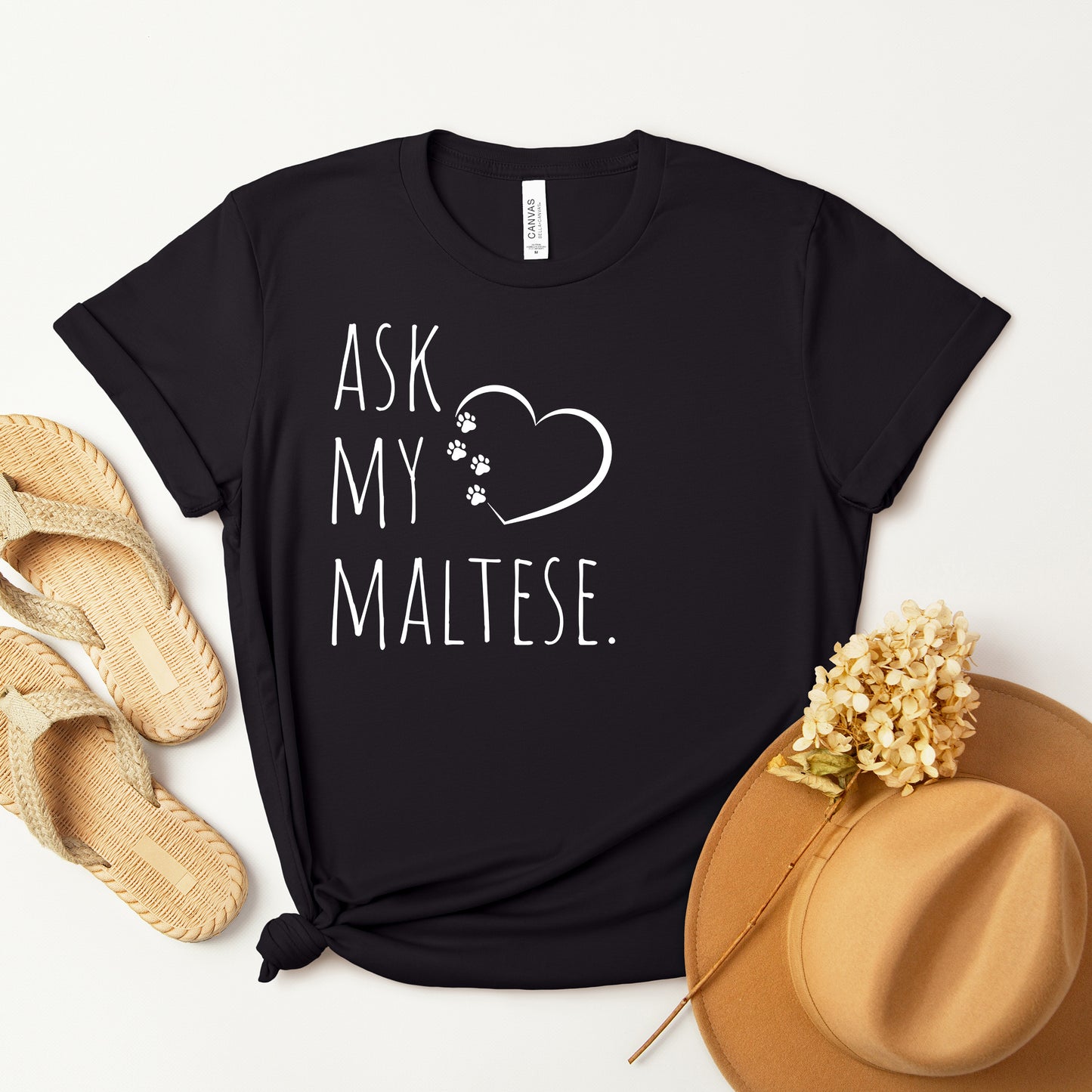 "Ask My Maltese" T-Shirt featuring a heart with two paw prints, perfect for dog lovers and Maltese owners. Unisex design for men and women. Available in multiple colors and sizes. Bella+Canvas 3001 t-shirt in black. ReadyShirtAim.com