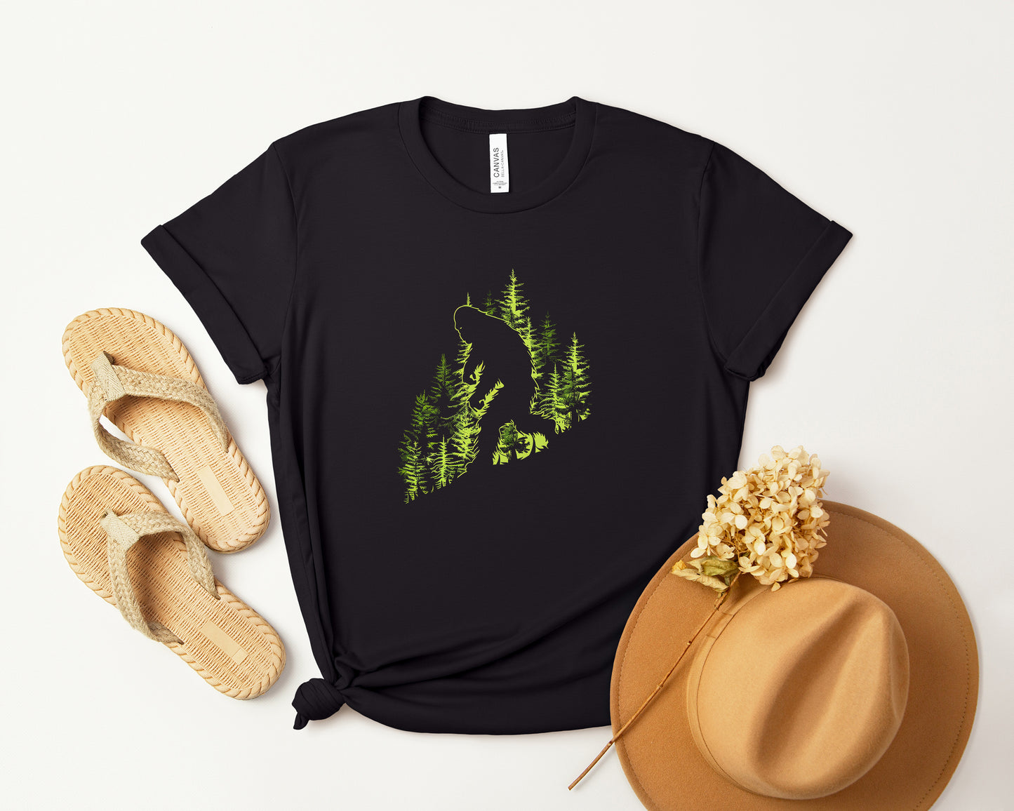 A t-shirt featuring an artistic depiction of a Bigfoot encounter, perfect for cryptid enthusiasts, outdoor adventurers, and mystery lovers. Comfortable and stylish for casual outings or cryptid conventions. Bella+Canvas 3001 t-shirt in black. ReadyShirtAim.com