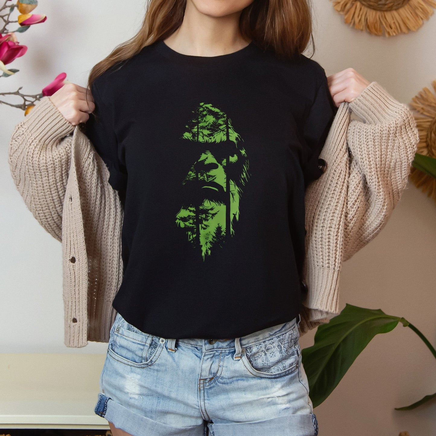 A t-shirt featuring an enigmatic cryptid design of Bigfoot's face, perfect for Bigfoot enthusiasts, cryptid fans, and adventure seekers. Comfortable and stylish for casual outings or cryptid conventions. Bella+Canvas 3001 t-shirt in black. ReadyShirtAim.com