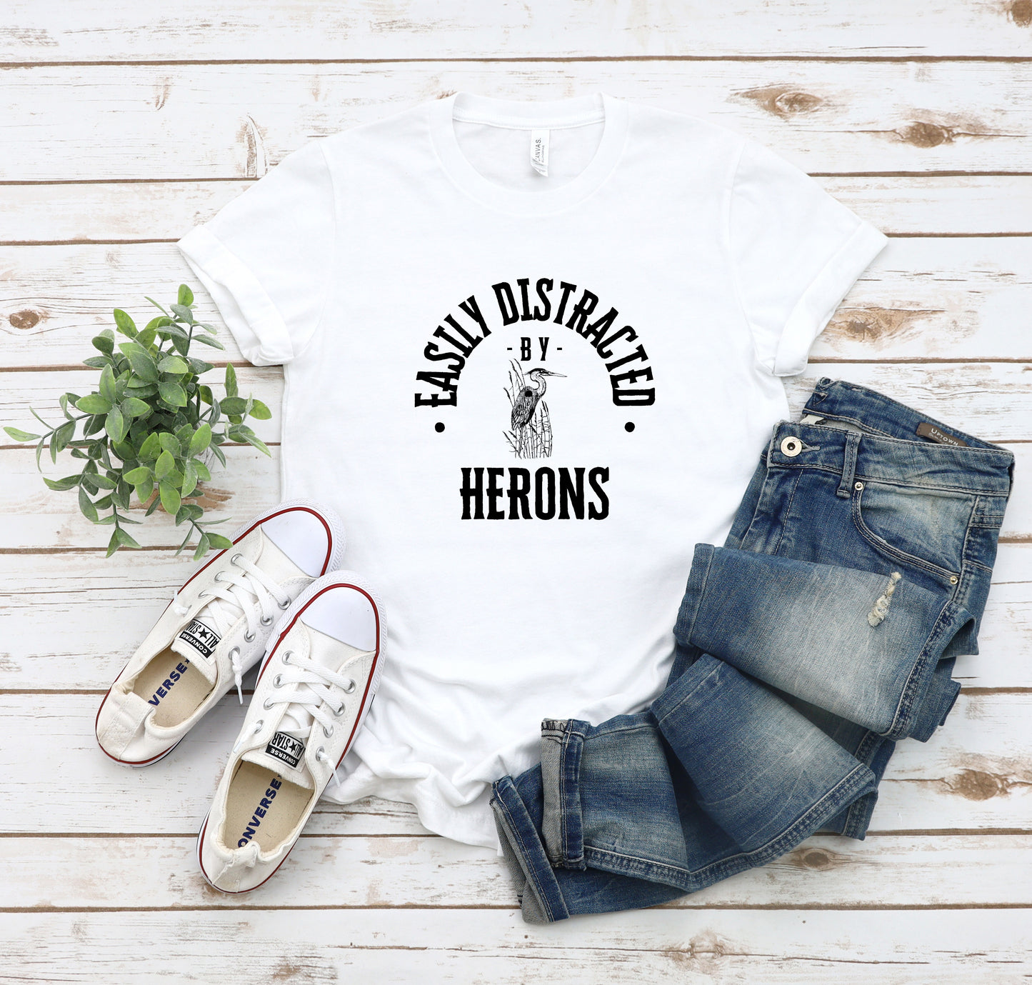 A vintage typeface t-shirt with a hand-drawn sketch of a heron and the caption "Easily Distracted by Herons." Perfect for heron lovers, bird watchers, and nature enthusiasts.