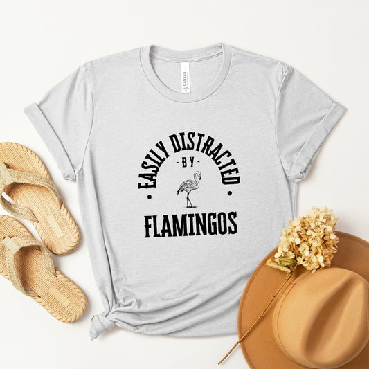 A vintage typeface t-shirt with a hand-drawn sketch of a flamingo and the caption "Easily Distracted by Flamingos." Perfect for flamingo lovers, bird watchers, and wildlife enthusiasts. Bella+Canvas 3001 t-shirt in ash. ReadyShirtAim.com