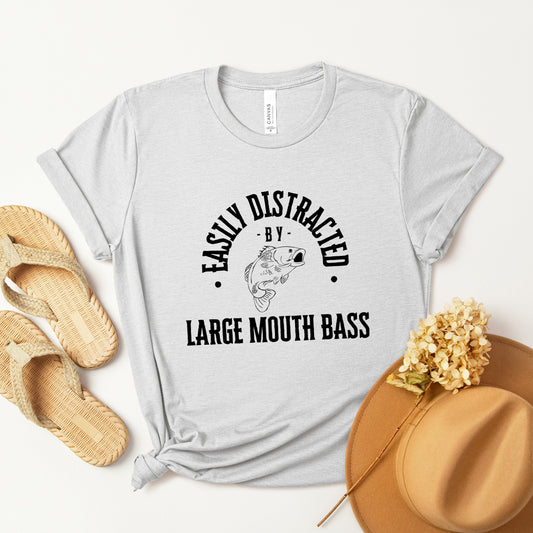 A vintage typeface t-shirt with a hand-drawn sketch of a large mouth bass and the caption "Easily Distracted by Large Mouth Bass." Perfect for bass lovers, anglers, and fishing enthusiasts.  Bella+Canvas 3001 t-shirt in ash. ReadyShirtAim.com