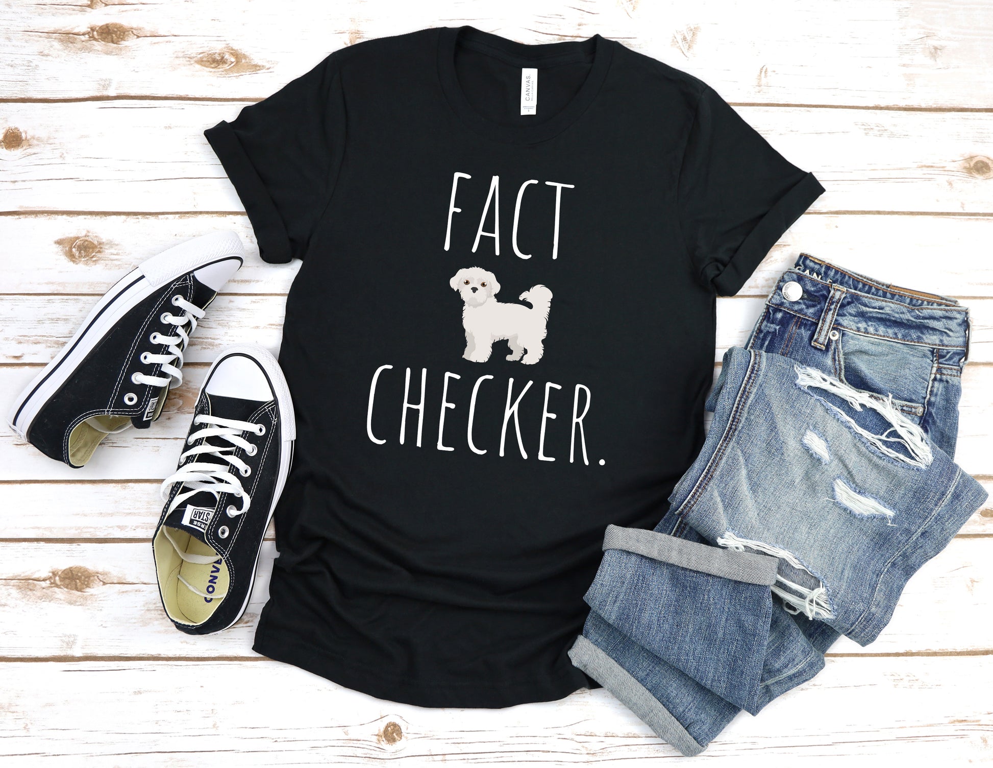 "Fact Checker" Maltese Dog T-Shirt for Unisex with a cute graphic of a Maltese dog and playful "Fact Checker" text underneath. Ideal for dog lovers. Ideal for dog lovers with a sense of humor. Available in multiple colors and sizes. Bella+Canvas 3001 t-shirt in black. ReadyShirtAim.com