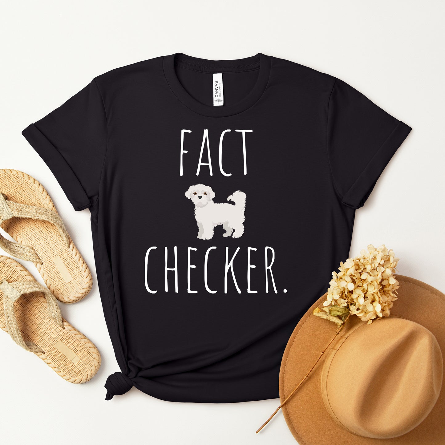 "Fact Checker" Maltese Dog T-Shirt for Unisex with a cute graphic of a Maltese dog and playful "Fact Checker" text underneath. Ideal for dog lovers. Ideal for dog lovers with a sense of humor. Available in multiple colors and sizes. Bella+Canvas 3001 t-shirt in black. ReadyShirtAim.com