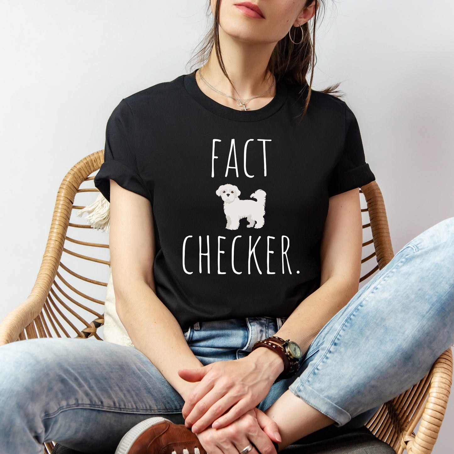 "Fact Checker" Maltese Dog T-Shirt for Unisex with a cute graphic of a Maltese dog and playful "Fact Checker" text underneath. Ideal for dog lovers. Ideal for dog lovers with a sense of humor. Available in multiple colors and sizes. Bella+Canvas 3001 t-shirt in black. ReadyShirtAim.com