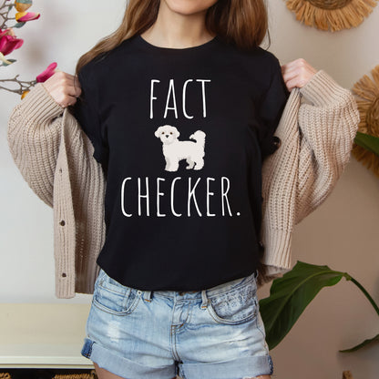 "Fact Checker" Maltese Dog T-Shirt for Unisex with a cute graphic of a Maltese dog and playful "Fact Checker" text underneath. Ideal for dog lovers. Ideal for dog lovers with a sense of humor. Available in multiple colors and sizes. Bella+Canvas 3001 t-shirt in black. ReadyShirtAim.com