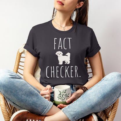 "Fact Checker" Maltese Dog T-Shirt for Unisex with a cute graphic of a Maltese dog and playful "Fact Checker" text underneath. Ideal for dog lovers. Ideal for dog lovers with a sense of humor. Available in multiple colors and sizes. Bella+Canvas 3001 t-shirt in dark grey. ReadyShirtAim.com