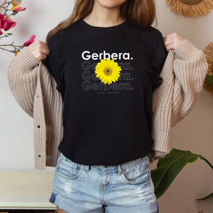 A photo-realistic yellow on yellow gerbera t-shirt with a bold contemporary floral design and the caption "Sunny Delight." Perfect for gerbera lovers, botanical enthusiasts, and nature lovers. Bella+Canvas 3001 t-shirt in black. ReadyShirtAim.com