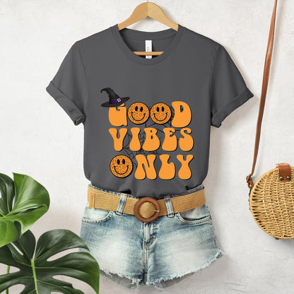 "Good Vibes Only" 70's Hippy Halloween Women's T-Shirt featuring bold orange, black, and animal print design, perfect for adding a groovy touch to your Halloween festivities. Available in multiple colors and sizes. Bella+Canvas 3001 t-shirt in asphalt. ReadyShirtAim.com