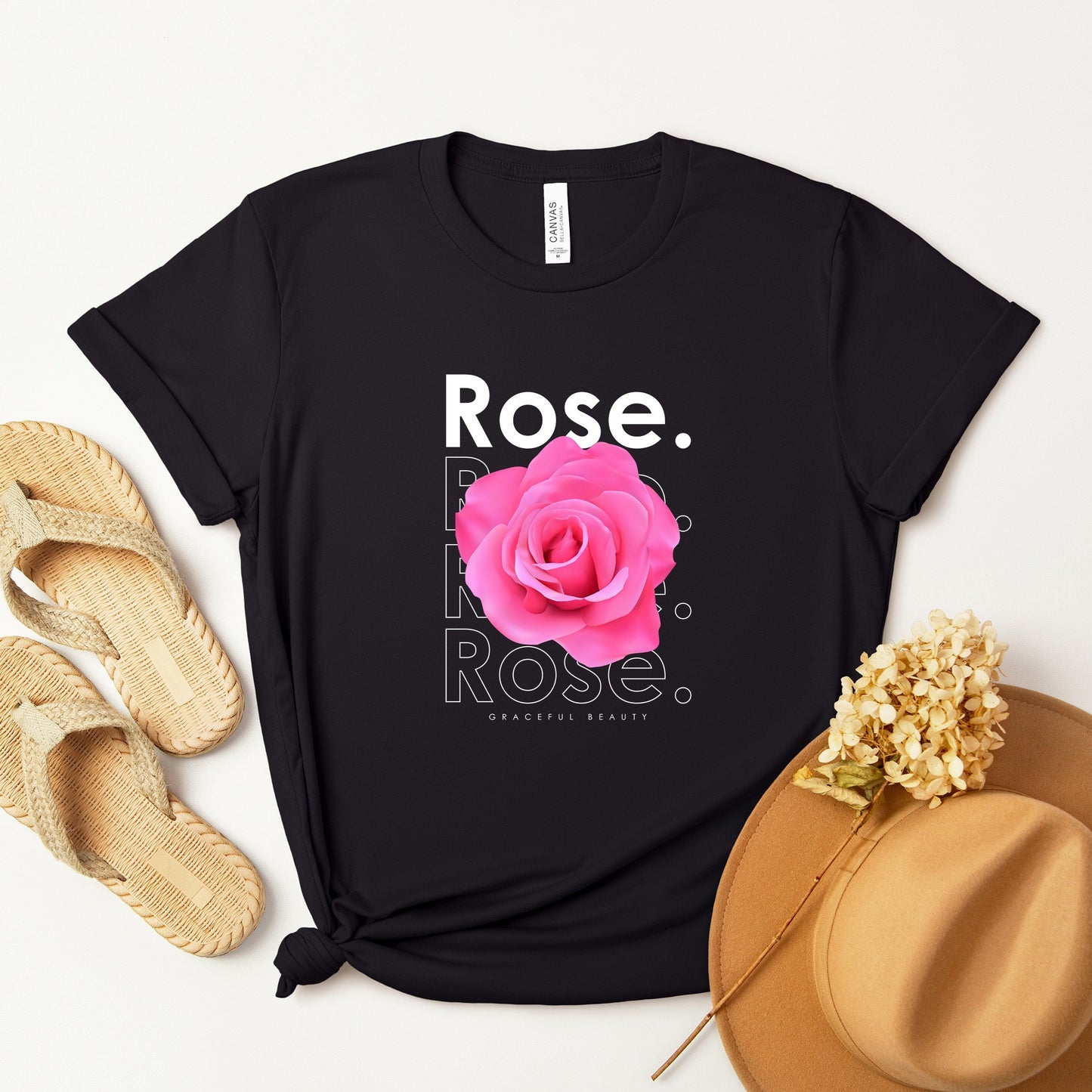 A t-shirt featuring a beautiful pink photo-realistic rose with the theme 'Graceful Beauty.' Perfect for those who adore floral art and nature. Comfortable and stylish for casual outings or celebrations. Bella+Canvas 3001 t-shirt in black. ReadyShirtAim.com